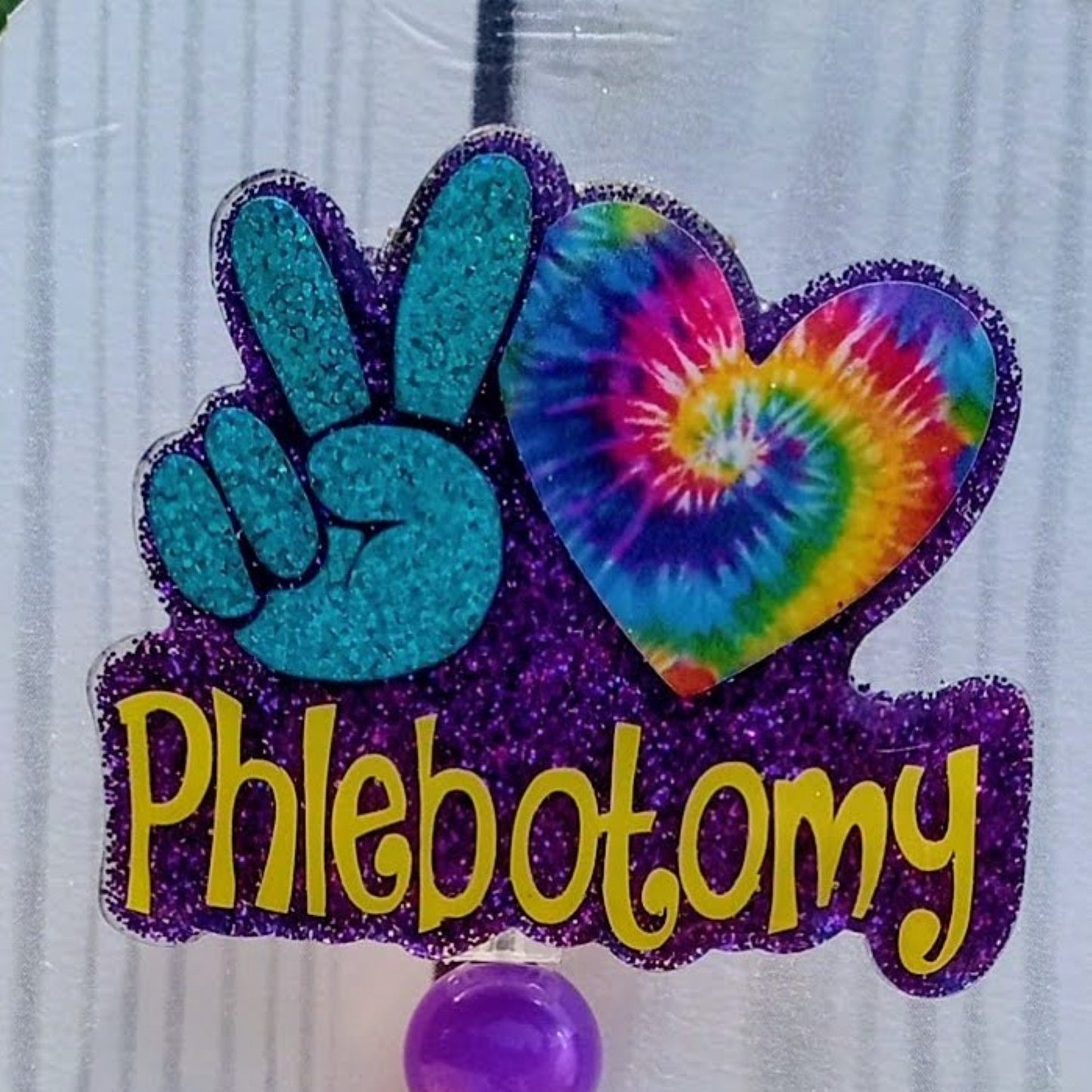 Colorful 'Phlebotomy' design with peace sign and tie-dye heart on a white background